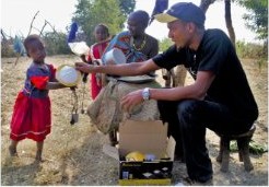 A GCS agent demonstrates a solar lamp to a family